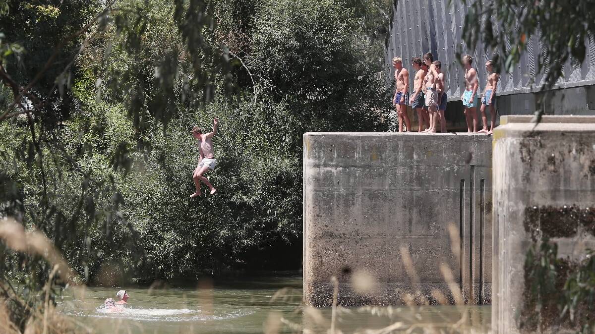 Teenagers jump from the Union Bridge after slipping through the $100,000 barriers put up last month to stop them. Pictures: JOHN RUSSELL
