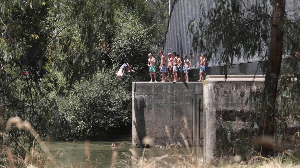 Teenagers jump from the Union Bridge after slipping through the $100,000 barriers put up last month to stop them. Pictures: JOHN RUSSELL
