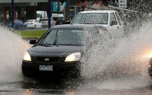 A car sprays up water on Raglan Parade in Warrnabool during Monday's storms.