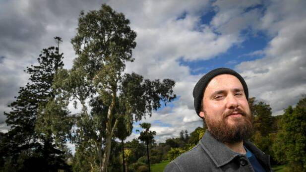 Ryan Prehn and the remnant river red gum, which could be up to 300 years old, according to the Royal Botanic Gardens. Photo: Eddie Jim
