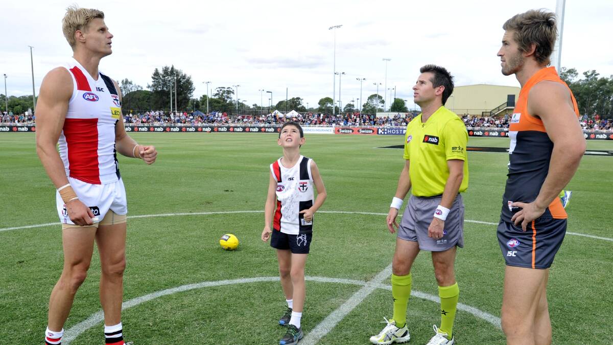 AFL: Nine-year-old Coolamon boy Jake Seymour flips the coin with St Kilda captain Nick Riewoldt and Giants co-captain Callan Ward. Umpire Scott Jeffery watches on. Picture: Les Smith 