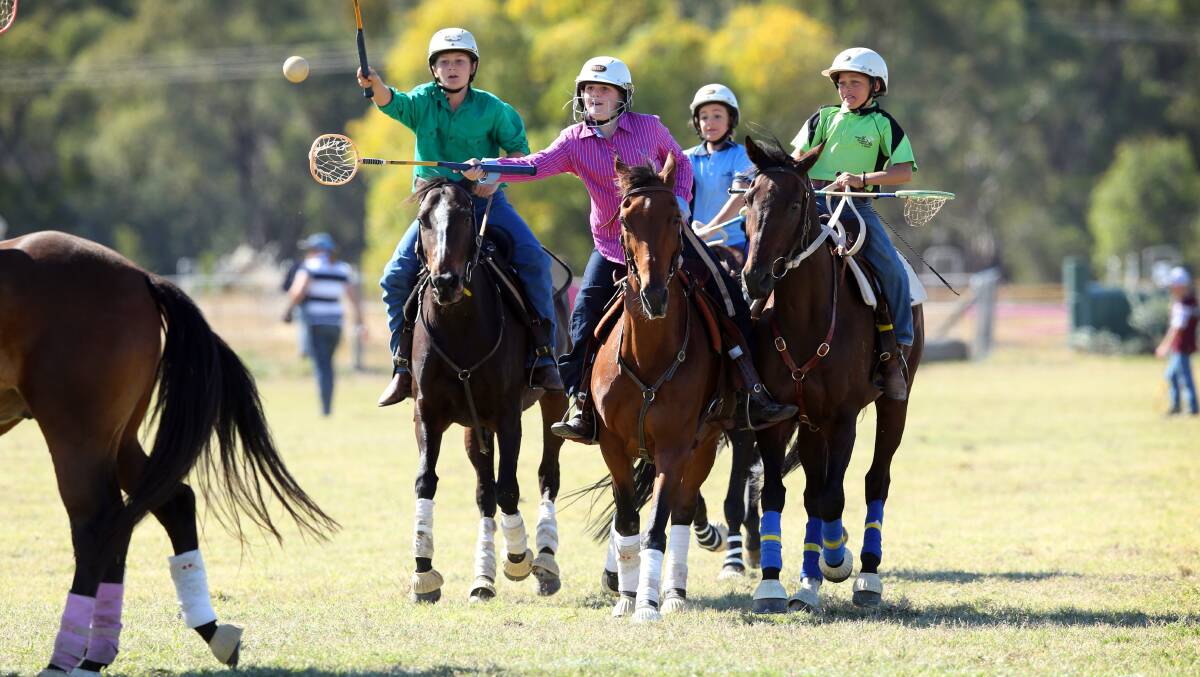 Jamie Knight,11, of Dirranbandi, Queensland, Hayley Constable, 12, of Wee Waa and Blair Beresford, 10, (in light green top) of Thargomindah, Queensland, during a coaching session on the polocrosse field.