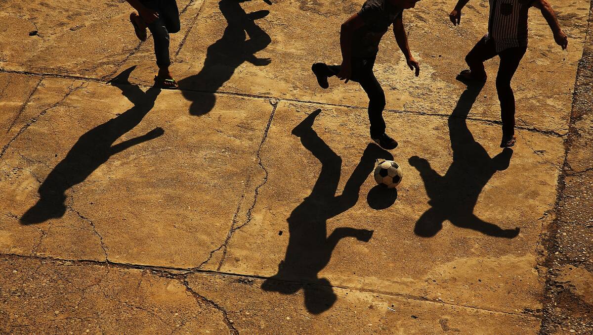Displaced Iraqi Christians play soccer in the courtyard of Saint Joseph's church after having to flee their district on June 26, 2014 in Erbil, Iraq. Photo by Spencer Platt/Getty Images.