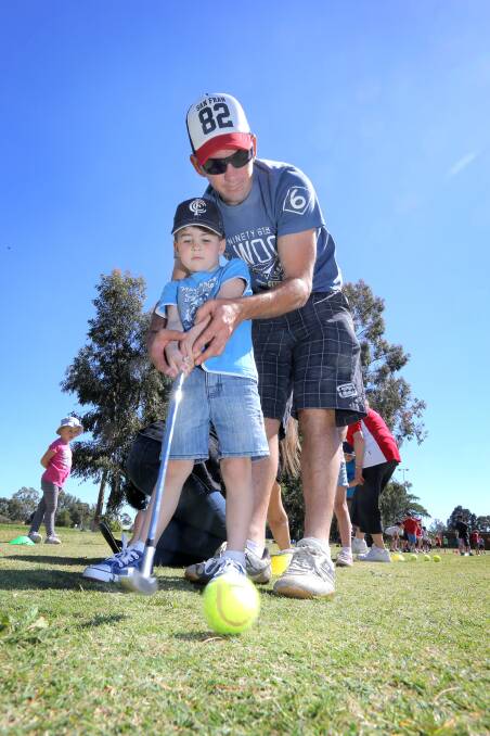 Howlong's Jason Kohn teaches his son Jed Kohn, 4, how to putt at the Howlong junior golf clinic day. Picture: TARA GOONAN
