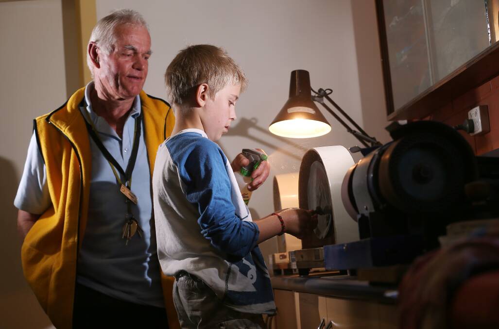 David Barrows shows Oliver Shepherd, 9, how to polish stones using wet/dry paper.Picture: JOHN RUSSELL