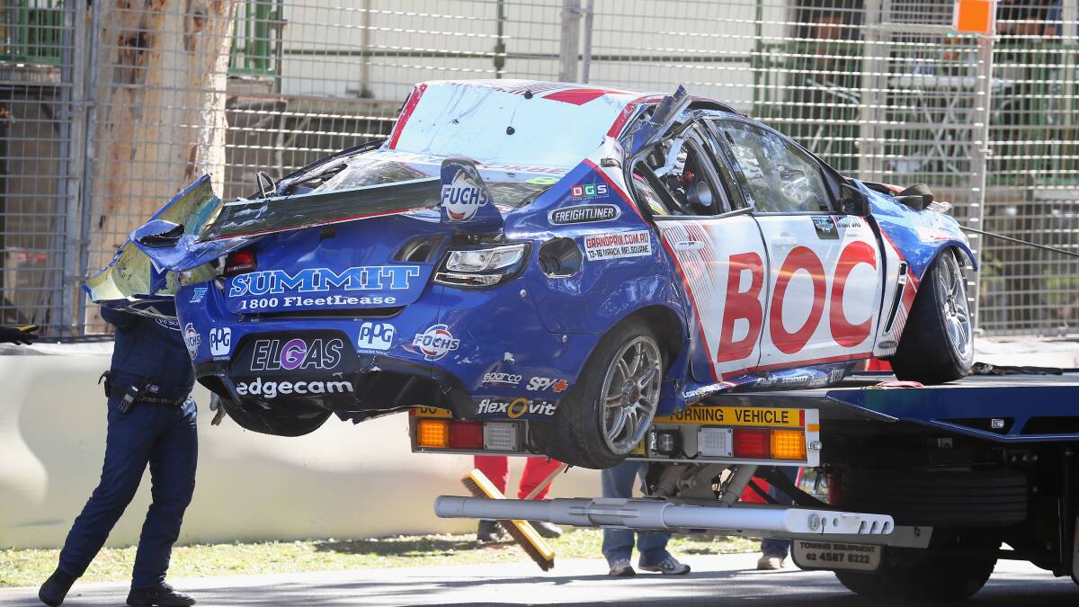 Mechanics take away the smashed No. 8 racing car. 