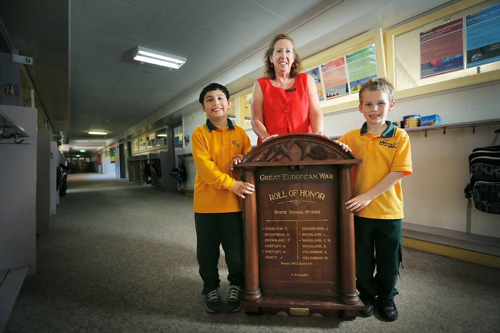 Defence Transition Aide Liz Haynes and students Josh Muscat, 8, and Lachlan Kelly, 7, took posession of the honour board. Picture: TARA GOONAN
