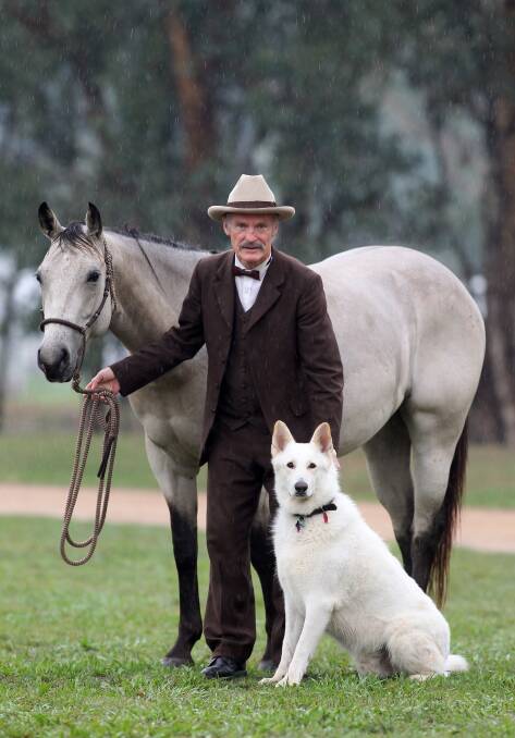 Geoffrey Graham leads Cherry the horse and Jinx the dog as he plays the character of Banjo Paterson.
