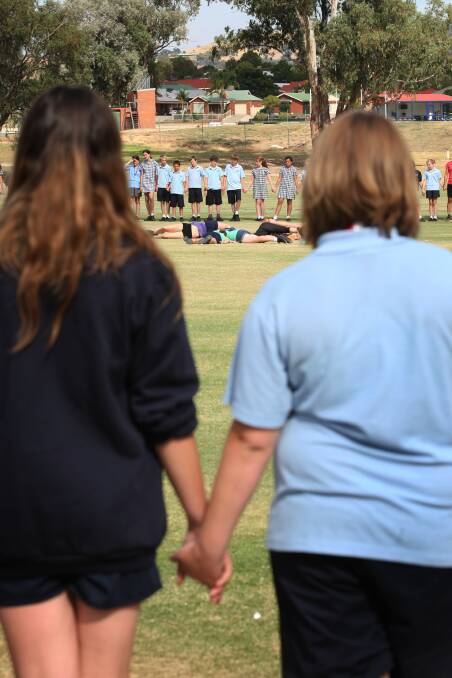 Wodonga Middle Years College students joined hands in a circle around the field then met in the middle to shake hands with other students. 