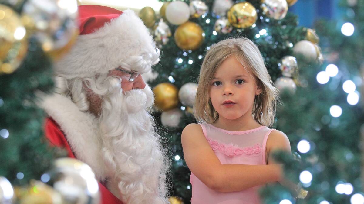 Jacinta Clarke, 6, from Springdale Heights, lets Santa know she’s been good this year and what she’d like for Christmas. Picture: BEN EYLES
