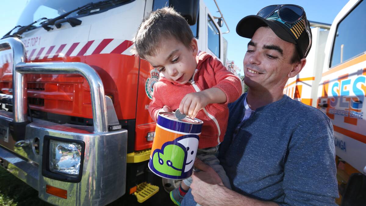 Wodonga CFA volunteer firefighter Shane O'Toole and his son, Benji, 3, put a coin in the Good Friday Appeal tin to help the hospital that gave Benji the best start to life. Picture: MATTHEW SMITHWICK