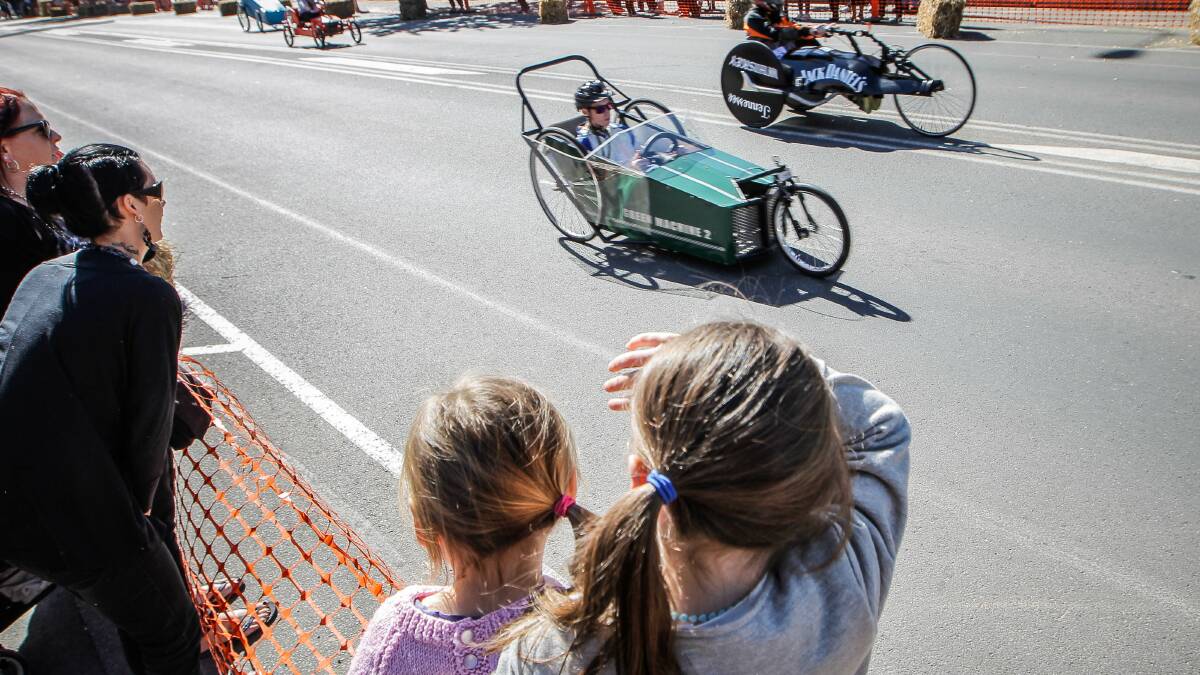 Melbourne's Audrey and Lillian Finn, aged 3 and 5, watch the carts go past as they visit family. 
