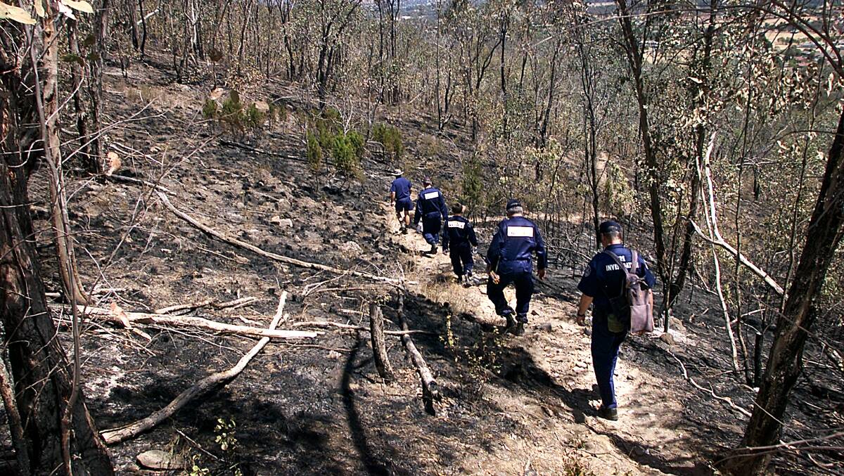 Fire investigators scour Nail Can Hill to find the source of a blaze there in recent days. Picture: SIMON GROVES