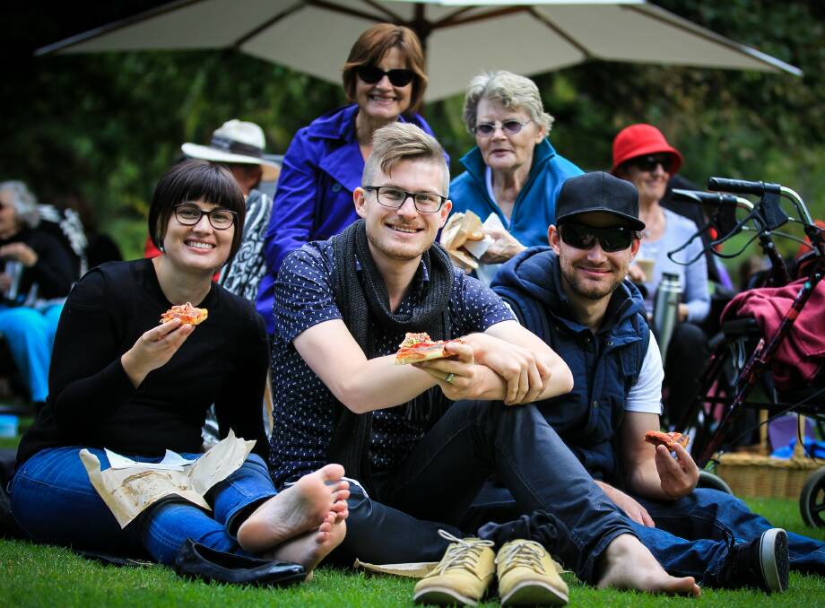 Wodonga's Amanda and Elliott Bailey, and Daniel Treloar, with Melbourne's Rosemary Snook (back left) and Vera Coles, also of Wodonga, having a slice of pizza as they listen to the music.