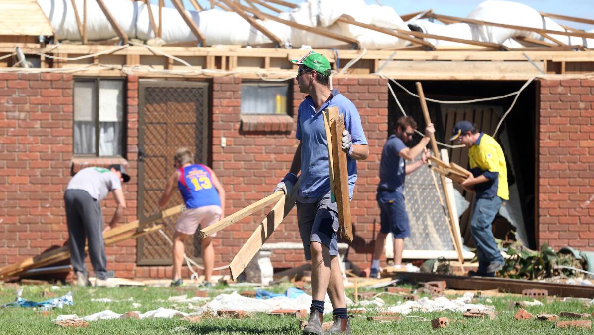 Members of the Mulwala Football Club cleaning up at a house next to the Denison Caravan Park in March. Picture: JOHN RUSSELL