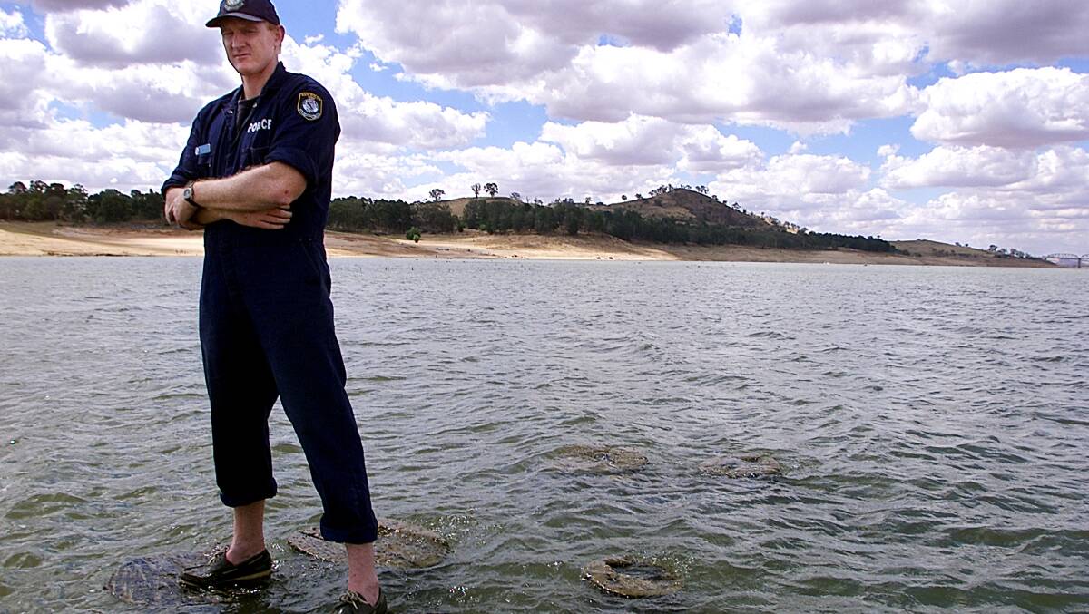 Sen-Constable Ken Howe is not God, he is simply demonstrating that the Lake has dropped so much that the tree stumps are now coming to the surface, creating a major problem for Boaties and skiers. Picture: SIMON GROVES