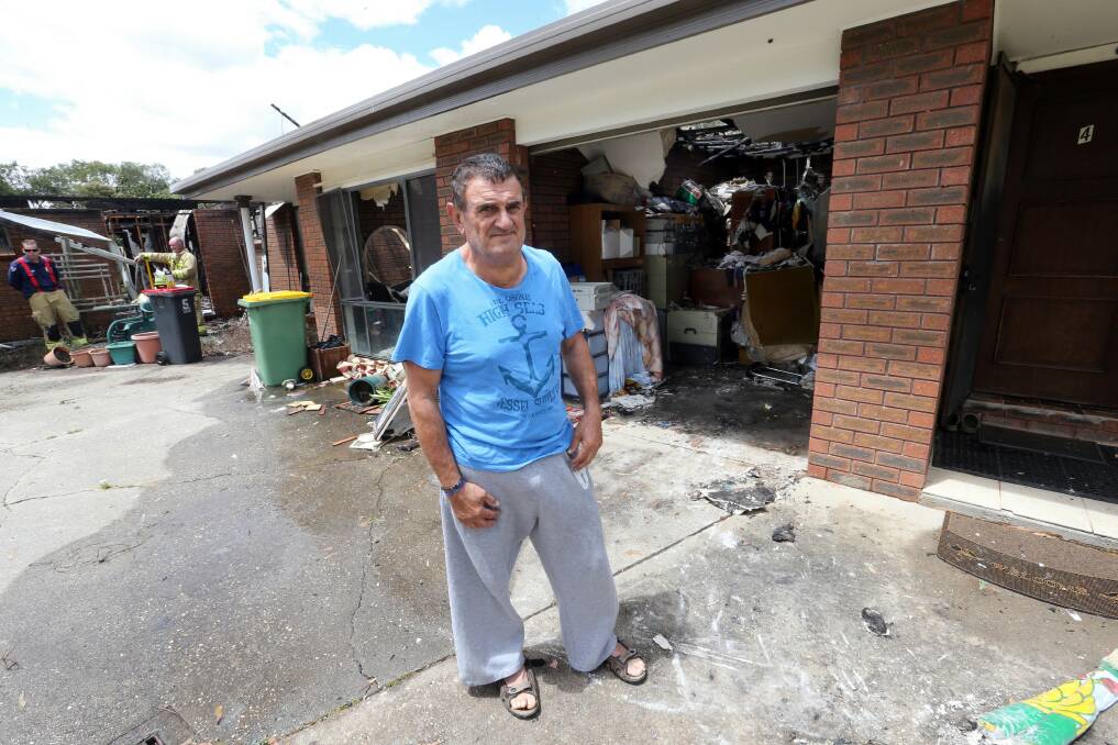 Peter Georgiou in front of his unit's garage, which has fire, smoke and water damage. Picture: PETER MERKESTEYN