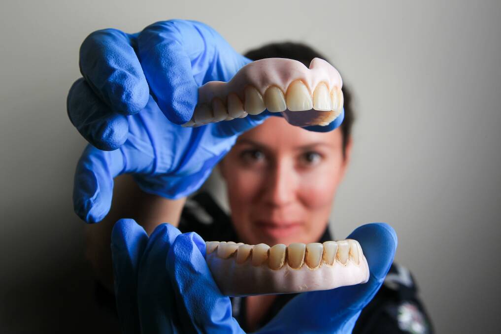 First Constable Renee Henderson with a set of false teeth that were handed into Wodonga Police Station. Picture: DYLAN ROBINSON