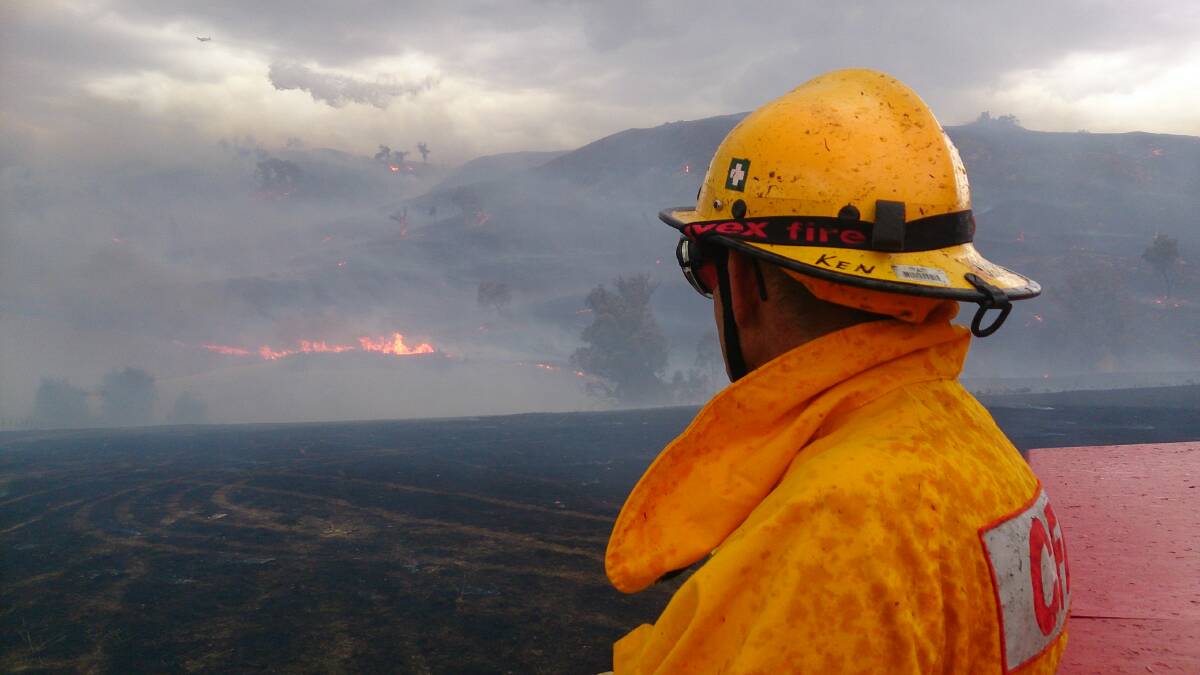 A firefighter looks out at the mixture of smoke and dark clouds cascading through the valley at Brewers Road, Leneva. Picture: Bruce Ray (email)
