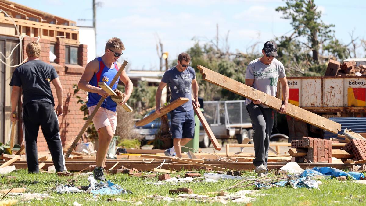 Members of the Mulwala Football Club cleaning up at a house next to the Denison Caravan Park in March. Picture: JOHN RUSSELL