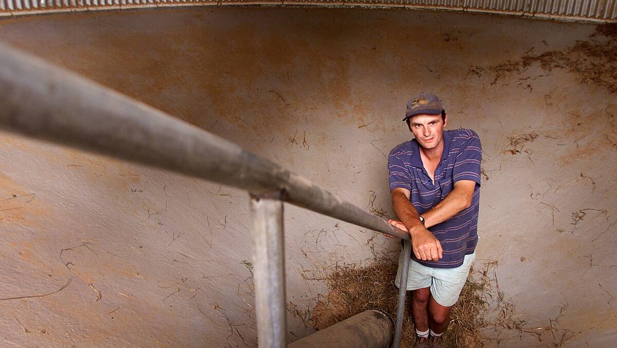 Justin Burns stands in an empty silo on his family's property near Burrumbuttock. The grain season has been poor due to the drought. In a good season this silo would be full. Picture: MATTHEW SMITHWICK