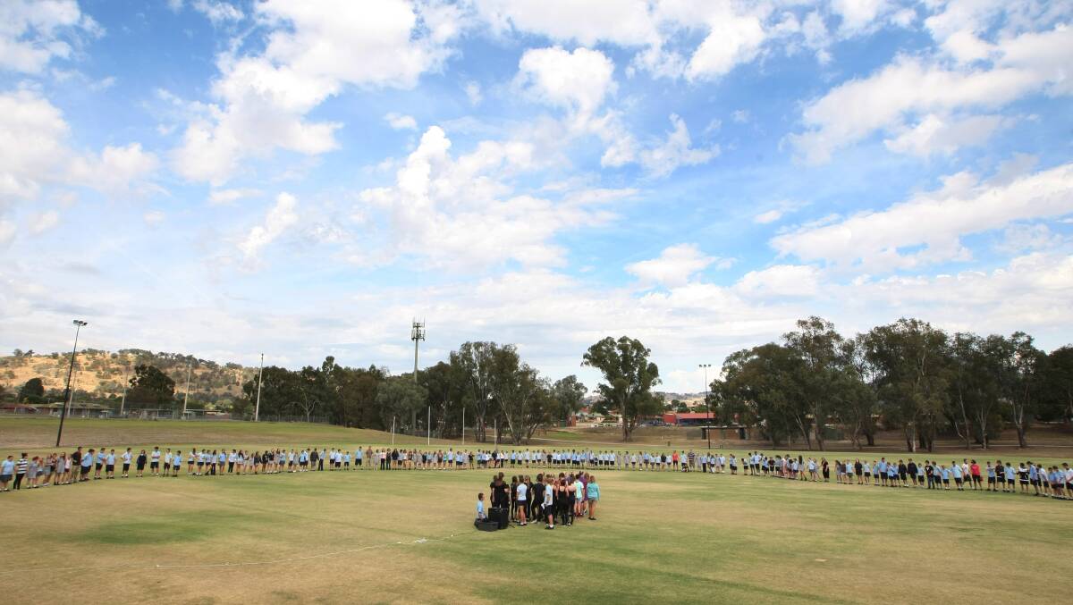 Wodonga Middle Years College students joined hands in a circle around the field then met in the middle to shake hands with other students. 