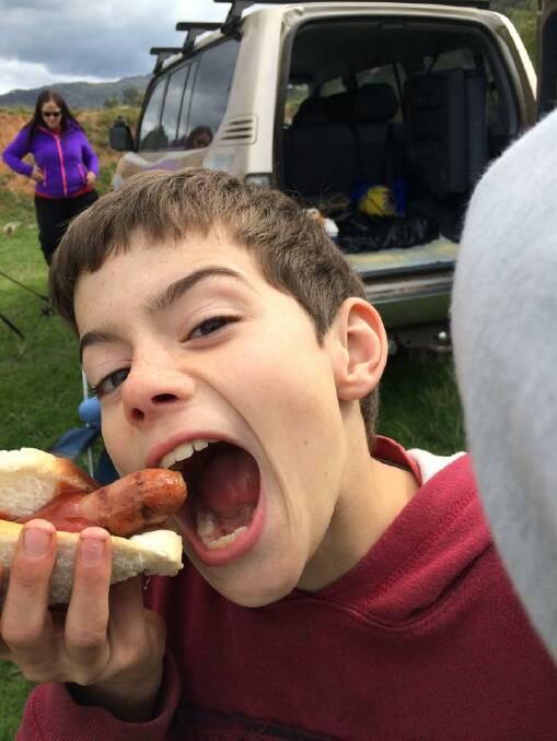 Thurgoona's Dylan Harmer hooks into a sausage in bread while camping in Colac Colac - MELINDA HARMER (Facebook)