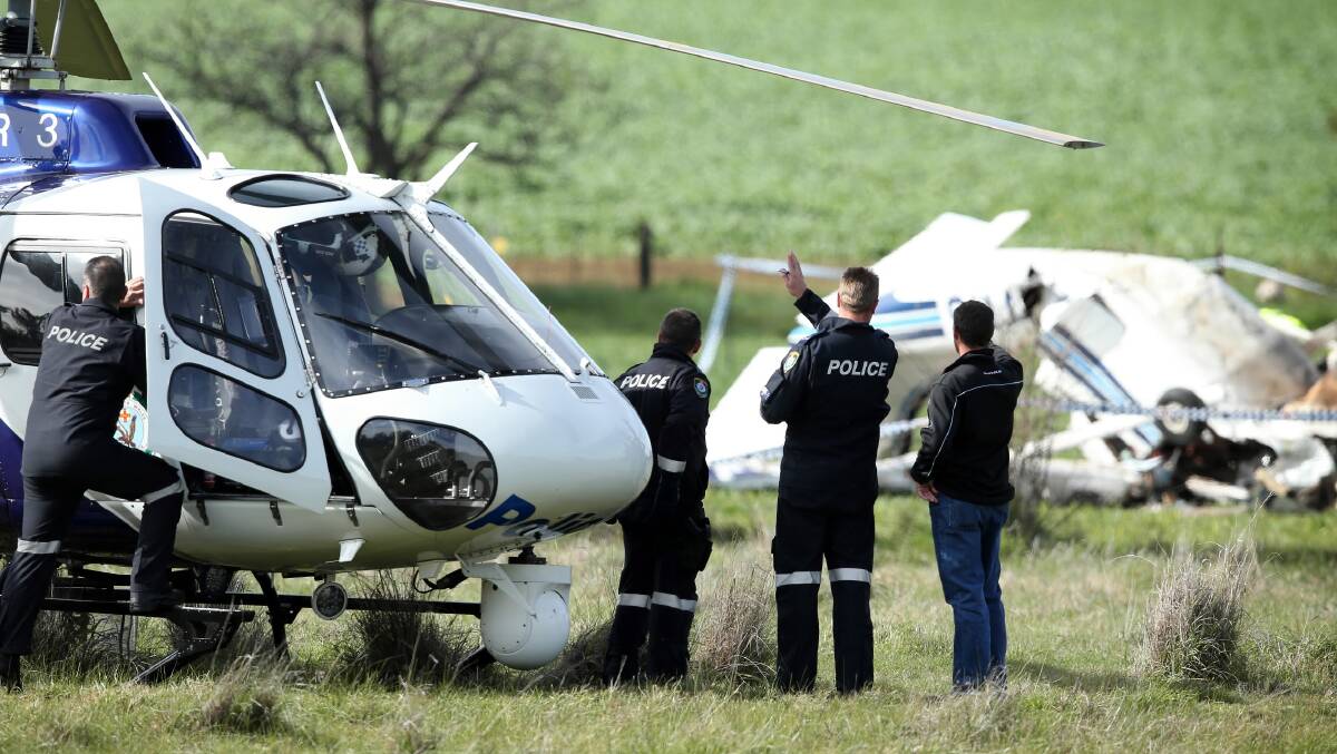 Officers from the NSW police helicopter, Polair, arrive at the scene of a fatal plane crash at Burrumbuttock in which the pilot Kris Barr died. Picture: MATTHEW SMITHWICK