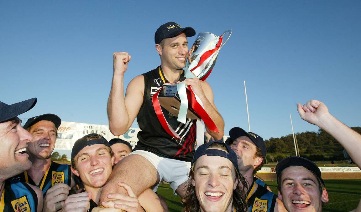Darryn McKimmie ­celebrates with the Ovens and Murray ­premiership cup after winning ­Lavington Panthers won the 2005 grand final.