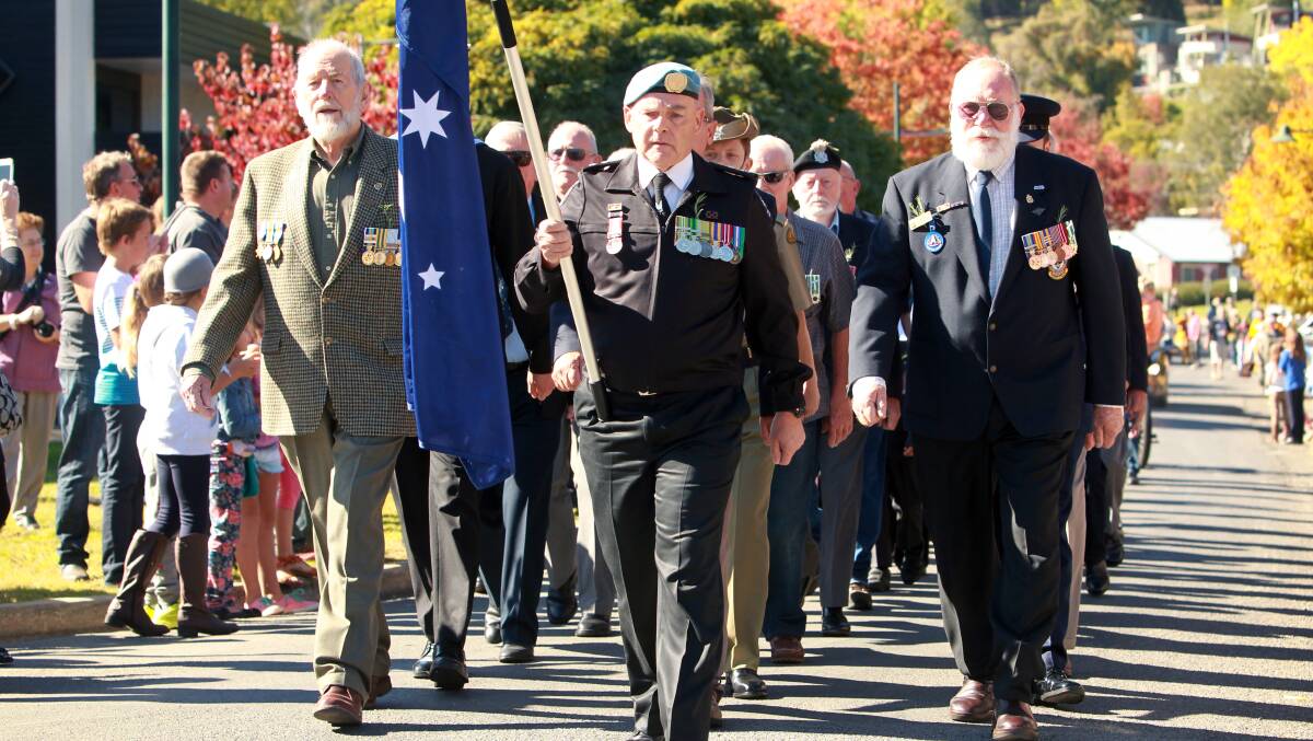 Ken Pickard, flag-bearer, leads the parade for the Anzac Day ceremony at Mount Beauty. Picture: MATTHEW SMITHWICK