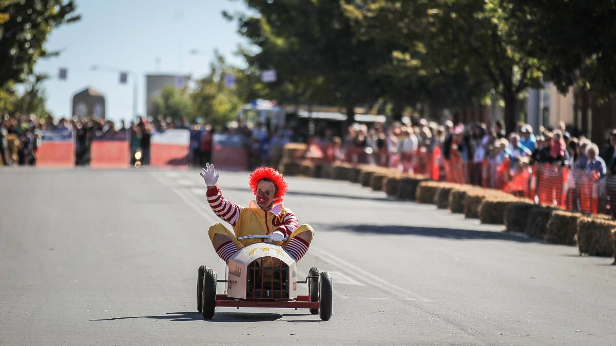 Todd Hayes, dressed as Ronald McDonald, rides his cart down the hill. 