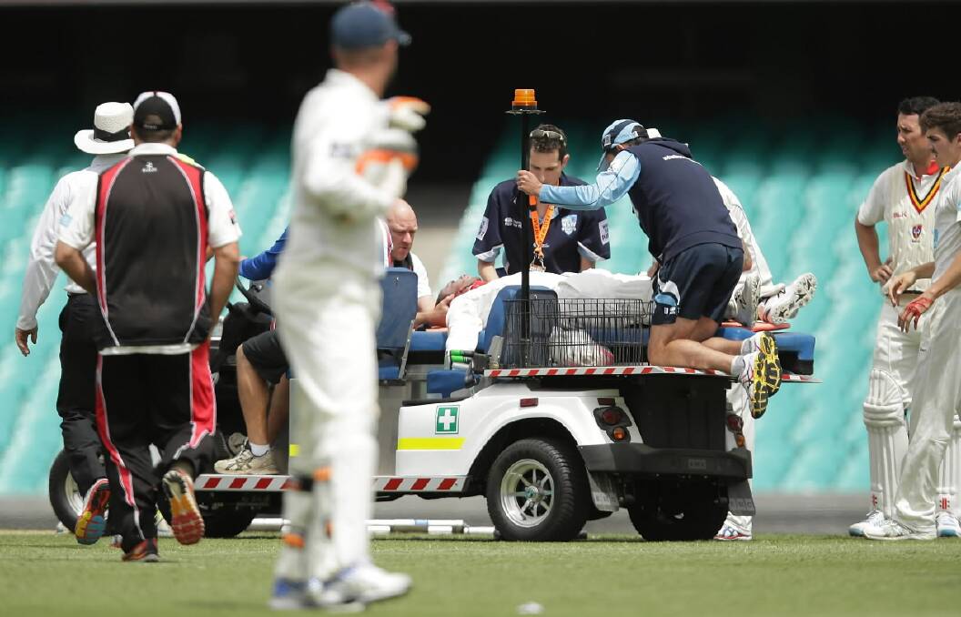 Phil Hughes is taken from the SCG after he was hit in the head by a bouncer yesterday. 