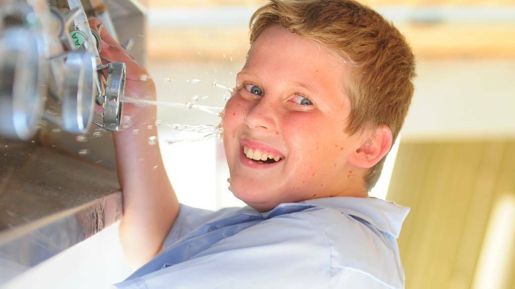DUBBO: St John's College student Harry O'Mally cools off in yesterday s heat. Photo LOUISE DONGES