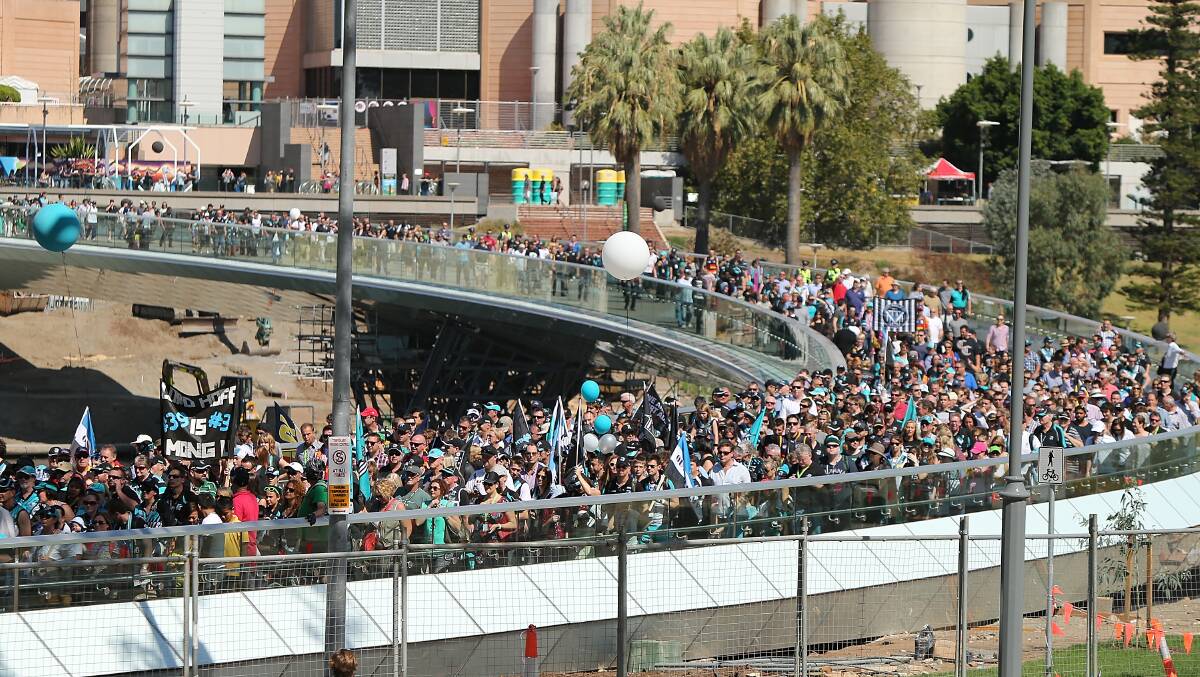 Spectators walk to the oval across the Torrens footbridge during the round two AFL match between the Port Adelaide Power and the Adelaide Crows at Adelaide Oval. Photos: Getty