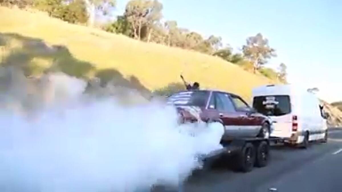 DANGEROUS: A still image from the footage posted on Facebook. The maroon Holden VK Commodore and white van both have signwriting on the rear. 