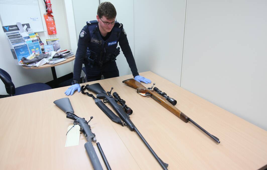 BACK IN SAFE HANDS: Constable Brendon Gordon with three stolen high powered rifles, one of which had been shortened: Pictures: BLAIR THOMSON