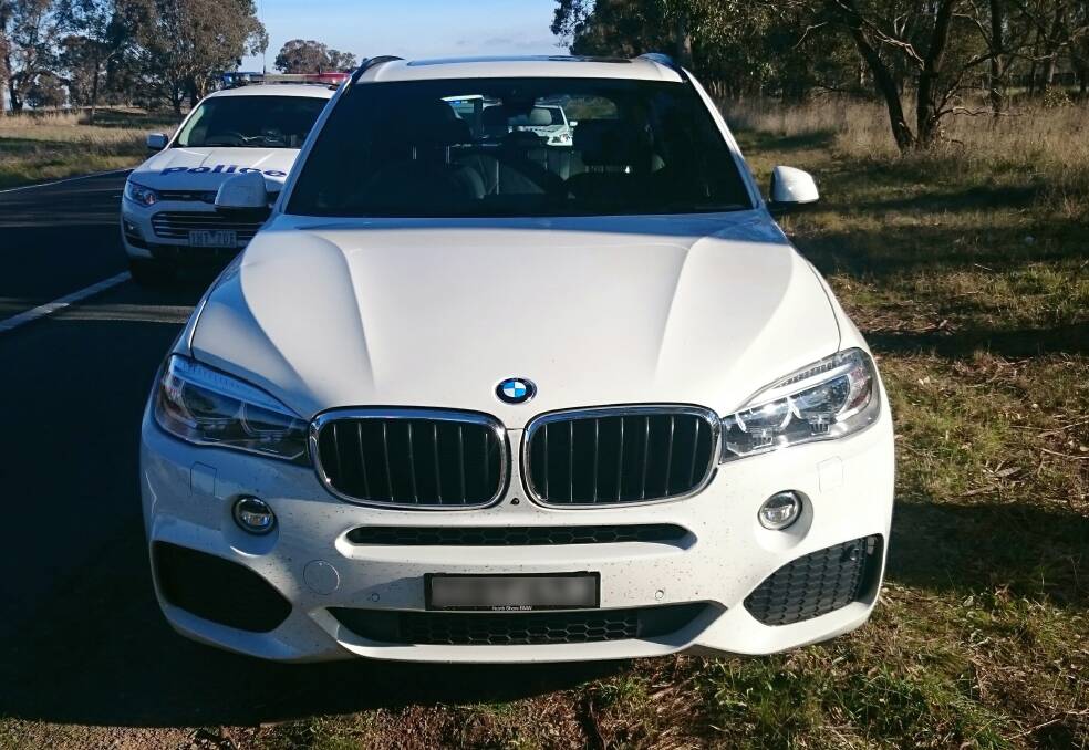 STOPPED: Police pull over a white BMW X5 on the side of the Hume Highway at Bowser on Tuesday afternoon. The car had hit close to 200km/h while travelling with another BMW, which police also pulled over. 