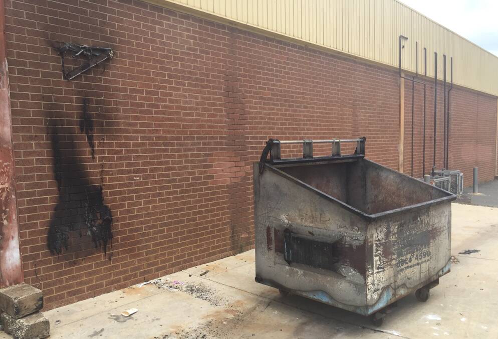 DAMAGE: Scorch marks can be seen next to a skip bin which was set alight at the rear of the shopping centre. 