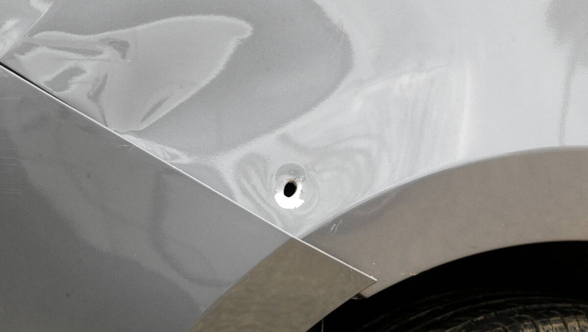 DAMAGE: A bullet hole in the side of the stolen car. 