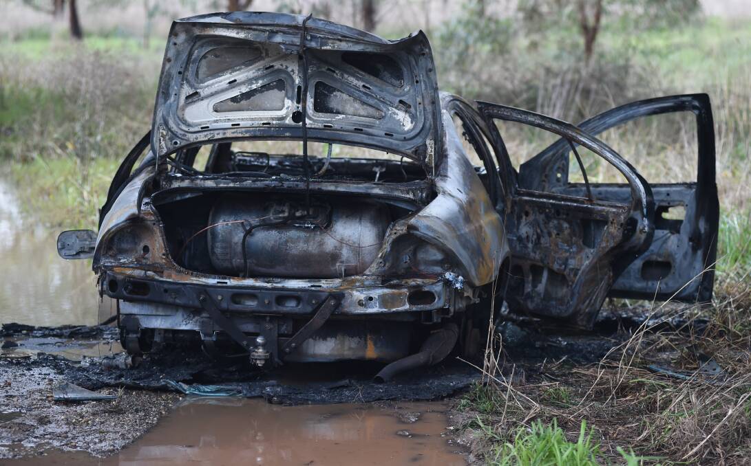 BURNT OUT: This Ford was destroyed by fire underneath the Spirit of Progress Bridge on the Hume Highway on Monday. Picture: MARK JESSER