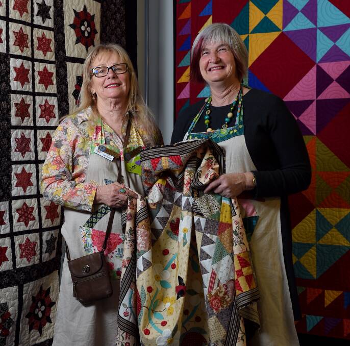 STITCHED UP: Indigo Quilt Exhibition organisers Jan Manglesdorf and Shelley Kelly with some of the designs on display at the event. The exhibition raised money for Alzheimer's Australia. Picture: JAMES WILTSHIRE