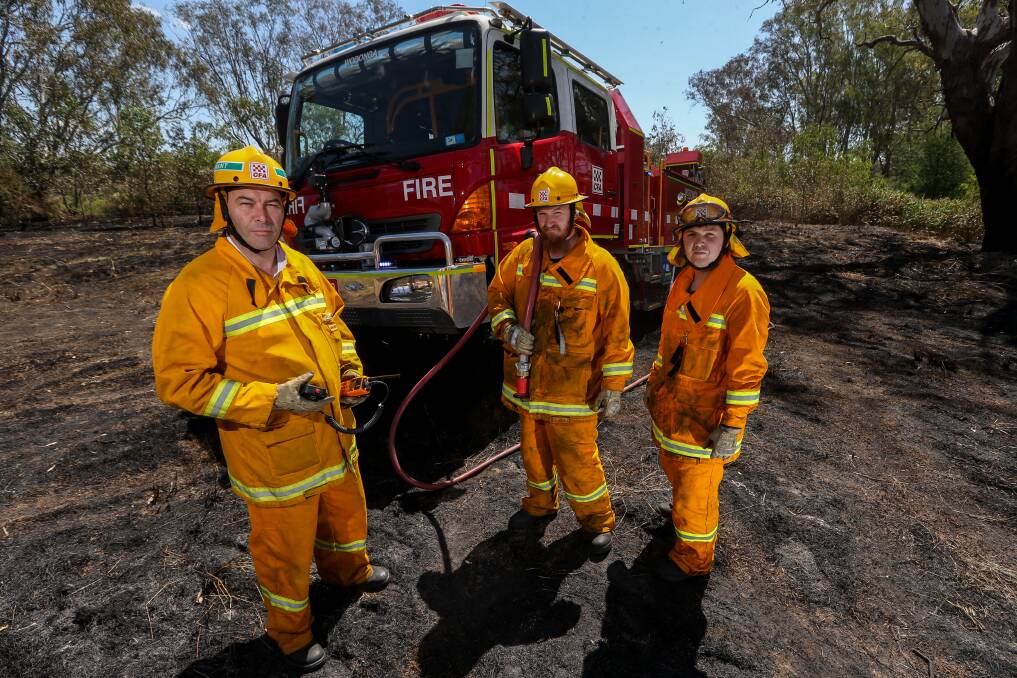 WARNINGS: Firefighters Gerard Peeters, Ben Mills and Brian Tyler at the scene of a fire near the stock route on Gateway Island on Friday. Picture: JAMES WILTSHIRE