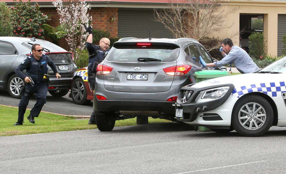 CHAOS: Police desperately try to smash the windows of the stolen car after their vehicles were rammed. Pictures: BLAIR THOMSON