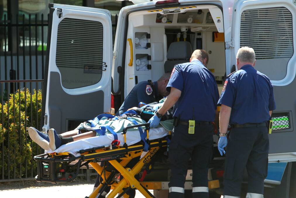 HELP: The student is assisted by paramedics at the school on Tuesday. Picture: BLAIR THOMSON