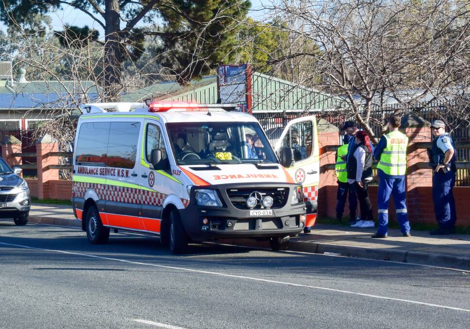 CRASH SCENE: Paramedics and police officers outside the school on Tuesday morning following the collision. The student wasn't badly hurt. Picture: BLAIR THOMSON