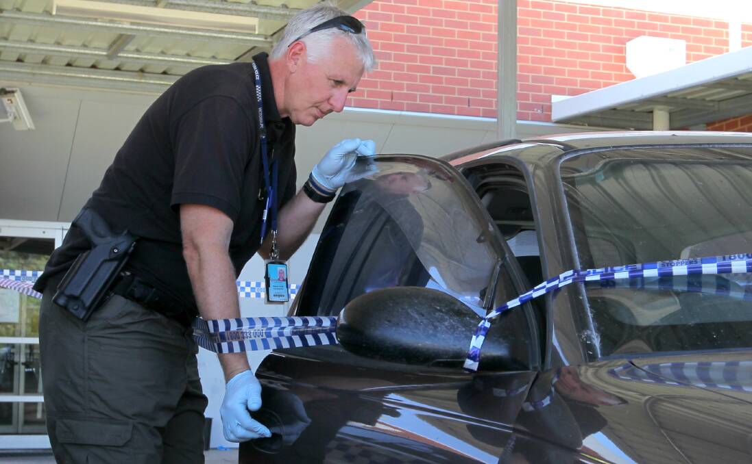 CHARGES LAID: Sergeant Peter McGuffie inspects a car connected to the double stabbing. 