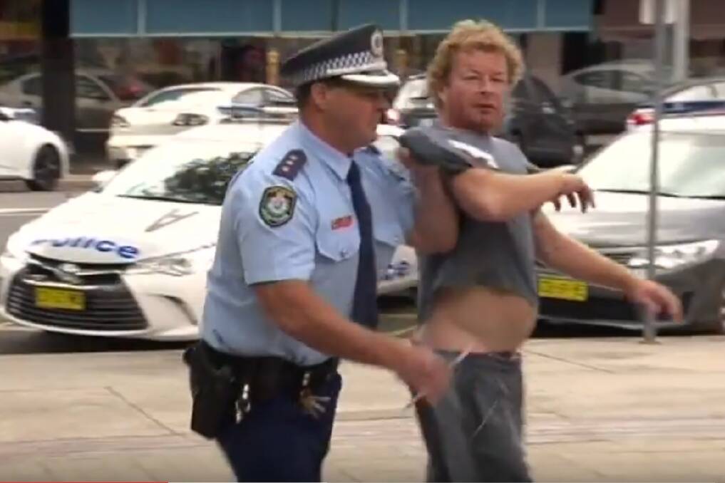 NABBED: The man is taken into custody for swearing in public after being told to pour out his beer. Picture: PRIME7 NEWS