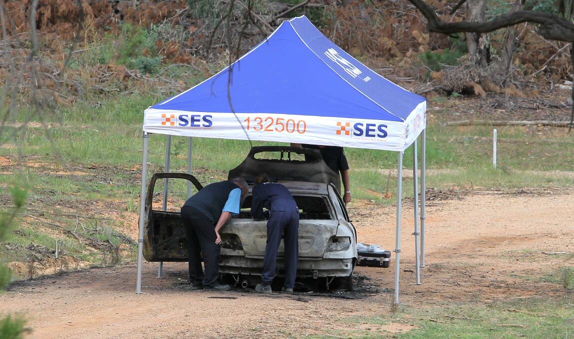 BURNT OUT: Police look through Ms Chetcuti Verbunt's burnt out vehicle on Halls Road. 
