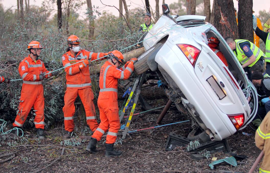 TRAPPED: SES members stabilise a car before cutting out the driver. Picture: BLAIR THOMSON 