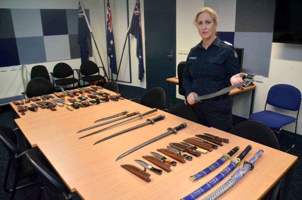 SEIZED: Senior Sergeant Kate Chamberlain with some of the knives and swords seized from the man's home in Wodonga on Friday. Picture: BLAIR THOMSON